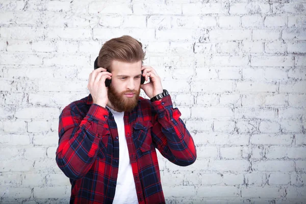 Joven Guapo Escuchando Música Mirando Hacia Otro Lado Mientras Está —  Fotos de Stock