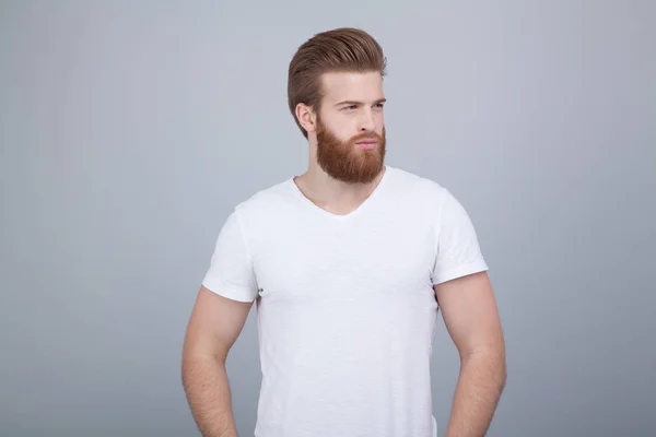 Varón serio y reflexivo con barba de jengibre, vestido casualmente, enfocado en algún lugar, aislado sobre fondo blanco —  Fotos de Stock