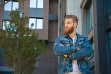 Genç sakallı adam kollarını karşı göğsüne ofis binası geçti.