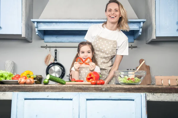 Eine schöne junge Mutter und Tochter haben Spaß beim Kochen — Stockfoto