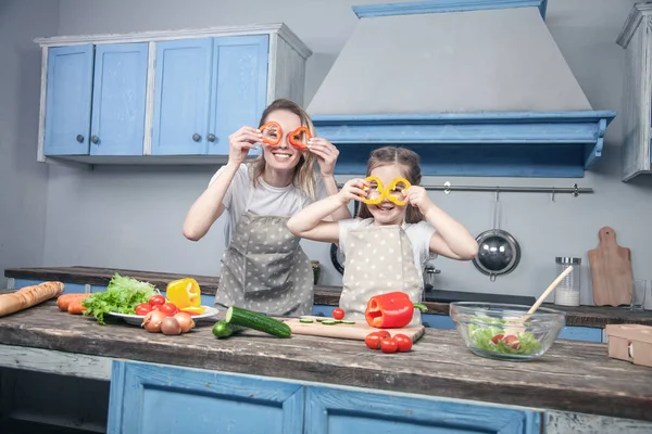 Eine schöne junge Mutter und Tochter haben Spaß beim Kochen — Stockfoto