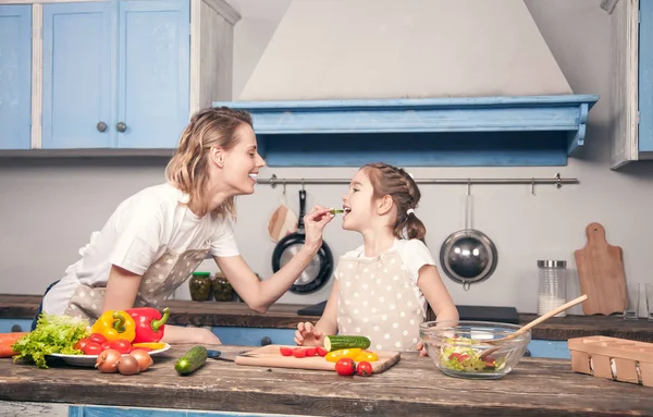 Linda madre le da a su dother un trozo de pepino al gusto —  Fotos de Stock