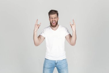 Gür kızıl sakallı başarılı bir adam. bir kaya işareti ile yükseltilmiş elleri ile çığlık, beyaz arka plan önünde durmak