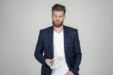Gür kızıl sakallı başarılı bir adam. dağıtılan bir para paketleri tutar. Takım elbise giymiş. beyaz arka planın önünde durmak