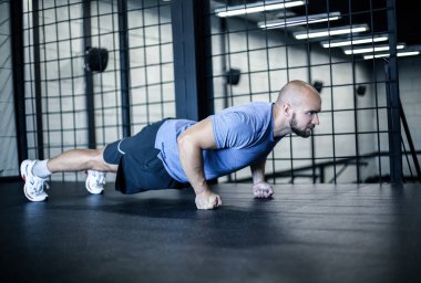 Spor. Şınav yapan genç atletik adam. Kaslı ve güçlü adam egzersiz. bir spor üniforması giymiş.