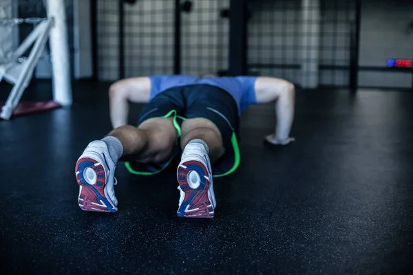 Un push-up parfait. Vue arrière du jeune homme en tenue de sport faisant push-up à la salle de gym — Photo