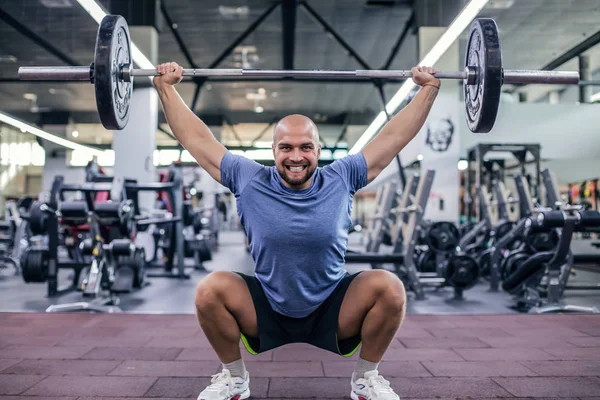 Soulever le poids et crier. Jeune homme beau en tenue de sport levant haltère à la salle de gym — Photo