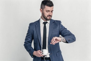 Zamanında orada olmalıydım. Kendine güvenen işadamı bilek saatini arıyor ve beyaz bir arka planda izole onun kahve tutar.