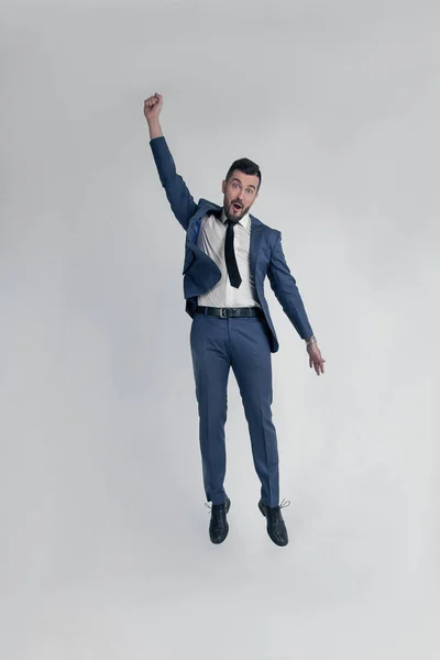 Retrato de un hombre de negocios divertido y poco loco saltando y animando en voz alta aislado sobre un fondo blanco — Foto de Stock