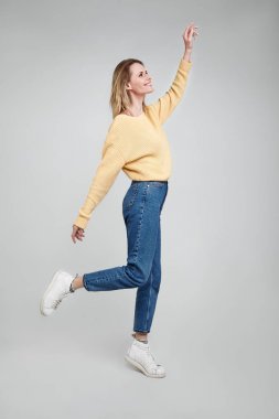 Sevimli güzel kız bin yıllık tam uzunlukta vücut boyutu görünümü fotoğraf whight arka plan üzerinde el heyecanlı giyinmiş denim giysiler tutun izole duygu özgürlük aptal yürüyüş