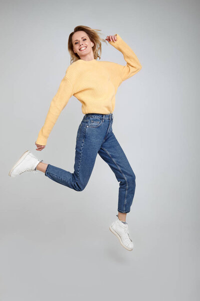 Weightlessness. Full legs, body, size portrait of lovely surprised girl with blonde hair looks straight into the camera with wide open hands isolated on shine white background