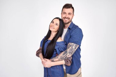 Güzel çift sıcak sarılmak var, aile portresi için poz, sevinçle gülümseme, iyi ilişkiler var. Sevecen kardeşi beyaz duvar üzerinde izole kız kardeşi kucaklar. Kız arkadaşı ve erkek arkadaşı tarih var