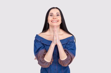 Namaste, barış seninle olsun. Kot pantolon elbise koyu saçlı mutlu samimi görünümlü genç kadın portresi, göğüs üzerinde dua el ele tutuşan ve tapınakta Budistler ağırlarken geniş gülümseyerek