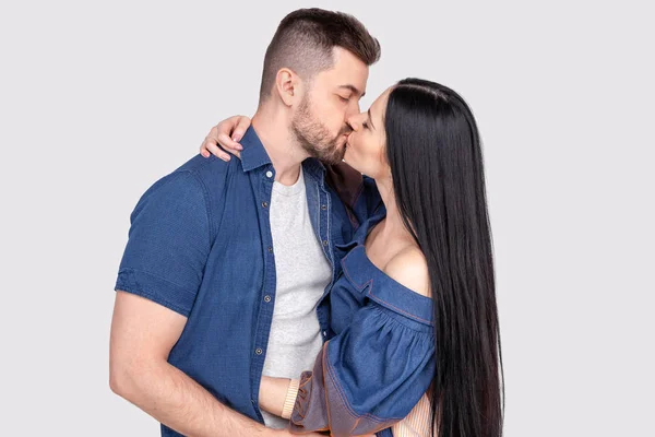 Primer plano de pareja romántica joven es besar y disfrutar de la compañía de los demás. aislado usando ropa de mezclilla sobre fondo gris ceniza — Foto de Stock