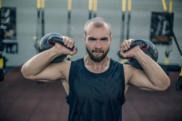 Athlète cross fit faisant de l'exercice avec une kettlebell au gymnase. Un bel homme qui fait de l'entraînement fonctionnel. Entraînement pratique — Photo