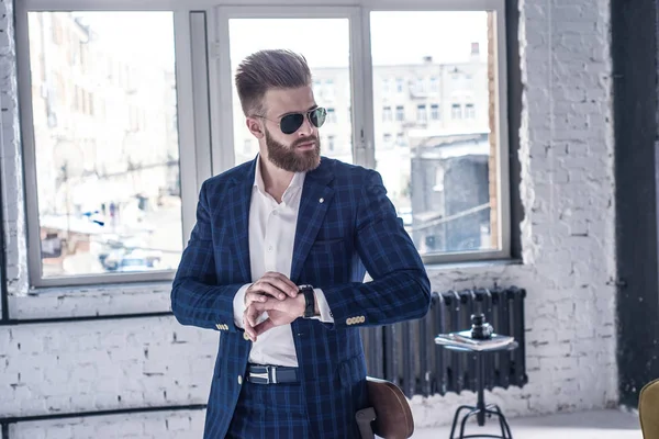 Elegante joven guapo hombre con barba con gafas y vigilantes. Loft estudio retrato de moda . —  Fotos de Stock