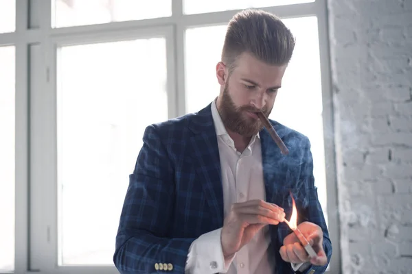 Un retrato de un hombre maduro guapo en un traje formal fumando un cigarro en el interior del desván. Belleza de los hombres, moda . — Foto de Stock