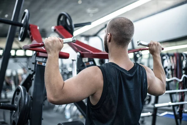 Νέοι Bodybuilder κάνει βαρέων βαρών άσκηση για πλάτη στο μηχάνημα — Φωτογραφία Αρχείου