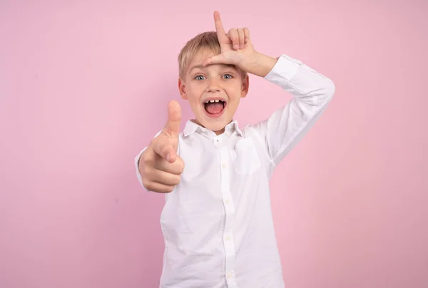 Портрет красивого смешного ребенка запугивания унижения смех детский игривый взволнованный одет в белую рубашку модный розовый фоновый дурак — стоковое фото