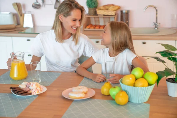 Υγιεινών τροφίμων στο σπίτι. Ευτυχισμένη οικογένεια στην κουζίνα. Κόρη μητέρα και το παιδί έχοντας πρωινό. — Φωτογραφία Αρχείου