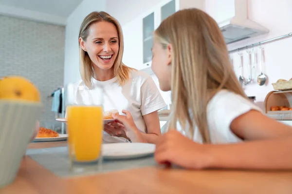 Nahaufnahme einer schönen jungen Mutter, die ihre Tochter mit blonden Haarkrapfen brachte. Niedliche Familie — Stockfoto