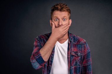 Yeni söylentiler duyan adam şok oldu ve hayrete düştü. Nefes nefese kalırken ağzı açıldı, kameraya patlak gözlerle baktı. Gri duvarda dedikodular duyduğuna inanamadı..