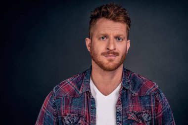 Saçma sapan konuşuyorsun, şüphe sana güvenebilir. Kızıl saçlı hoşnutsuz yetişkin girişimci kameraya şüpheli bir şekilde bakıyor kaşlarını kaldırmış ve ciddi bir yüz ifadesiyle, etkilenmemiş ya da güvensizlik göstermiyor..