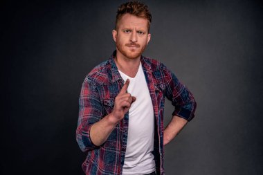 Bekle, sana yasaklıyorum. Ciddi görünümlü, kızıl saçlı, sakallı, işaret parmağı sallayan ve kameraya hoşnutsuz bir şekilde bakan, hayır ya da hayır diyen, belinden el ele tutuşan, azarlayan bir çocuk..