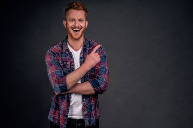 Arkadaşı ağaca çıktı, adamı işaret etti ve gülüp geçti. Neşeli, kaygısız ve neşeli, yakışıklı, erkeksi, kızıl saçlı, mavi tişörtlü, sol üst köşesini işaret eden ve bakan erkek..