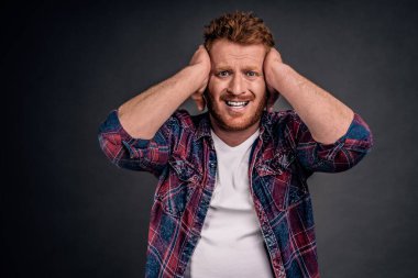 Lanet olsun büyük hata yaptım. Diş kasılıyor, kafasına elele ve çatık, her şey gri arka plan üzerinde kaybetme umutsuzluk hissi pişman, gri arka plan üzerinde endişeli duran erkekte portresi.