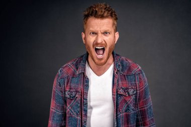 Beni aldattın. Nasıl yapabildin? Öfkeli ve mutsuz kızıl saçlı bir adam. Tüylü, bağıran, kaşlarını çatan, hoşnutsuz ifadeler takınan, ruhunda acı hisseden, gri duvarda tartışan..