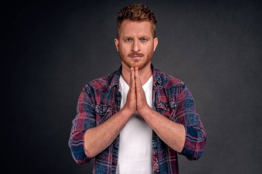 Sensei, dinliyorum. Ciddi görünümlü, kaslı, el ele tutuşmuş, namaste jesti yapan, Asya tarzı eğilen, gri duvarın üzerinden kameraya dik dik bakan kızıl saçlı yetişkin portresi..