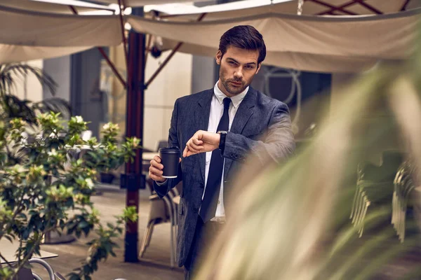 Joven Confiado Traje Completo Sosteniendo Periódico Mirando Reloj Mientras Está — Foto de Stock