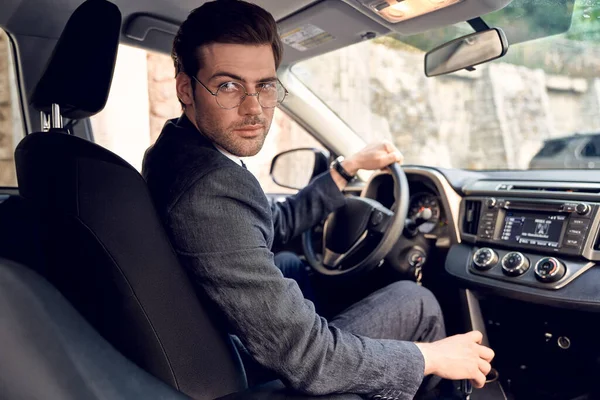 Selbstbewusster Junger Mann Anzug Und Brille Blickt Beim Ausparken Zurück — Stockfoto