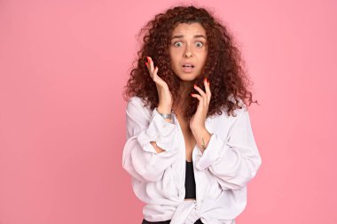 Şok olmuş, nutku tutulmuş, kızıl saçlı, mavi gözlü, çenesi düşmüş, dokunuşlardan etkilenmiş, şaşkın, şaşkın, şaşkın, rahatsız edici haberler, pembe arka plan..