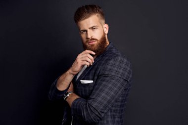 Genç hippi çene ve kamera bakarken siyah arka planda duruyor..