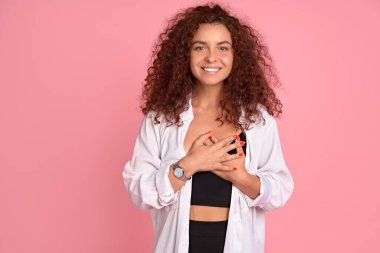 Pozitif neşeli kızın portresi tutkulu aşk tabelası pembe arka planda izole edilmiş günlük beyaz elbiseler giyer..