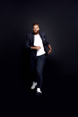 Tam boy fotoğraf, işe giderken sakallı, genç bir bilişim elemanı, siyahlar içinde izole edilmiş.