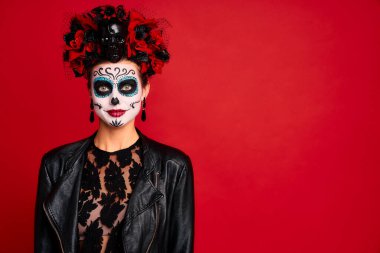 Genç, tüyler ürpertici bayan Calavera. Ölülerin ziyafeti için sanatsal makyaj yapıyor. Kafasında çiçek çelengi olan siyah deri bir ceket giymişti. Ölüler Günü 'nün sembolü kırmızıyla izole edilmişti.