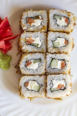 zencefil ve wasabi sopa ile bir plaka üzerinde rulo