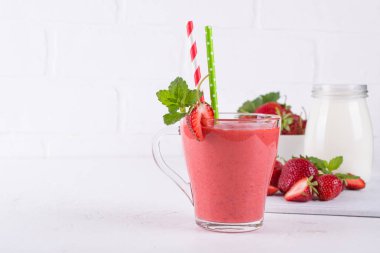 Çilek güler yüzlü veya milkshake cam Kupası'nda. Kahvaltı ve yemek için sağlıklı gıda