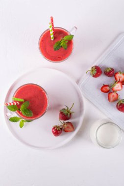 Çilek güler yüzlü veya milkshake cam Kupası'nda. Kahvaltı ve yemek için sağlıklı gıda. Üstten görünüm