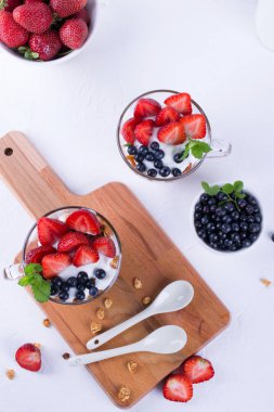 Yoğurtlu müsli ve meyveleri küçük cam bardak. Kahvaltı masası