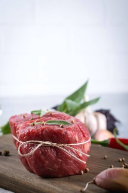 Çiğ et. Bir kesme tahtası Yeşiller ve baharat ile ham sığır eti biftek.