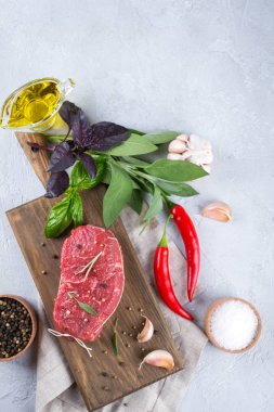 Kesme tahtası üzerinde yemek pişirmek için malzemelerle çiğ Dana biftek. Kopya alanı ile üstten görünüm