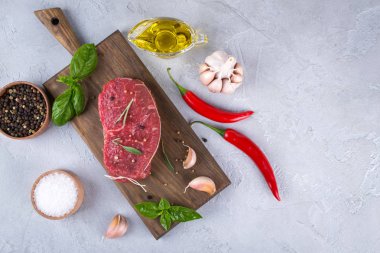 Çiğ et. Bir kesme tahtası Yeşiller ve baharat ile ham sığır eti biftek.