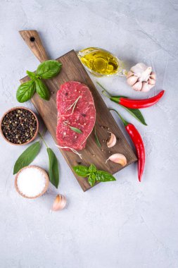 Çiğ et. Bir kesme tahtası Yeşiller ve baharat ile ham sığır eti biftek.