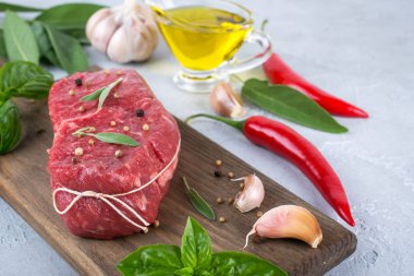 Çiğ et. Bir kesme tahtası Yeşiller ve baharat ile ham sığır eti biftek.