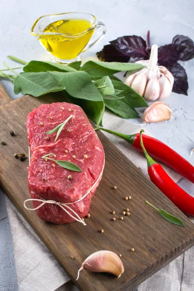 Kesme tahtası üzerinde yemek pişirmek için malzemelerle çiğ Dana biftek . 