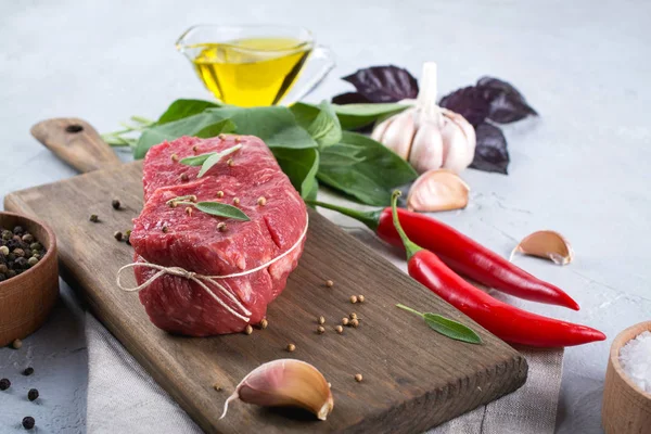 Kesme tahtası üzerinde yemek pişirmek için malzemelerle çiğ Dana biftek . 